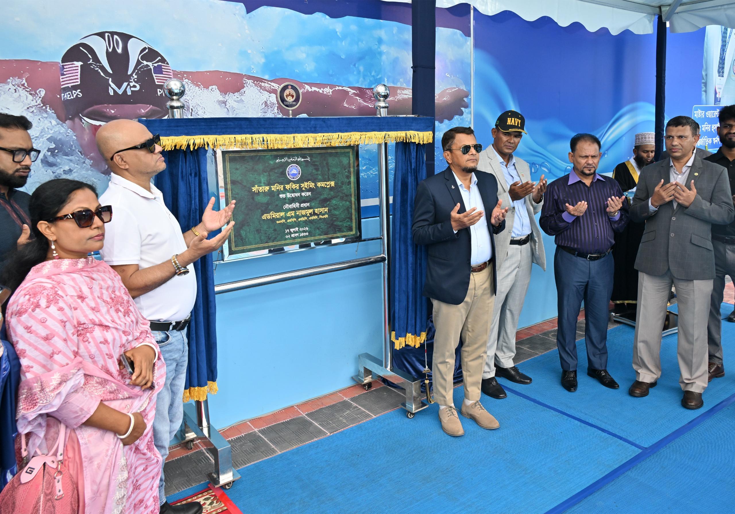 Officials and guests raise their hands in prayer beside the inauguration plaque, moments after its unveiling.